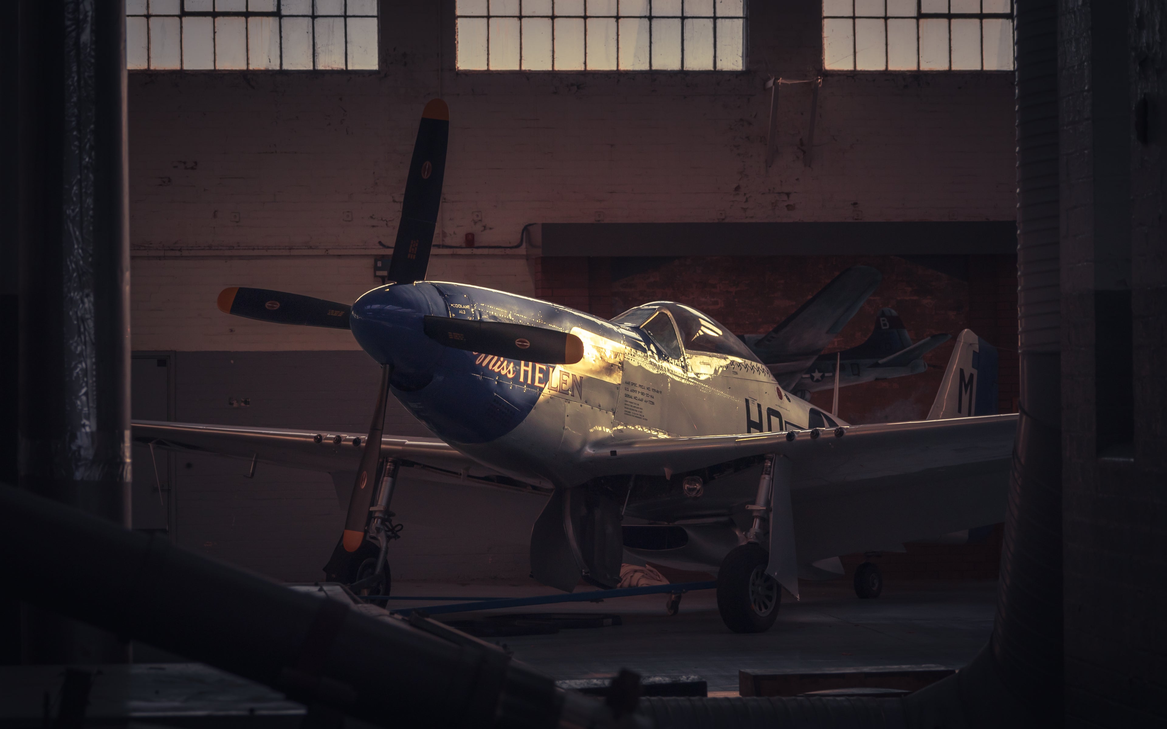 Vintage airplane inside a hangar with a warm glow