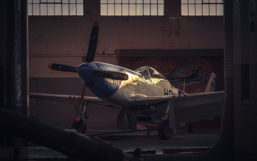 Vintage airplane inside a hangar with a warm glow